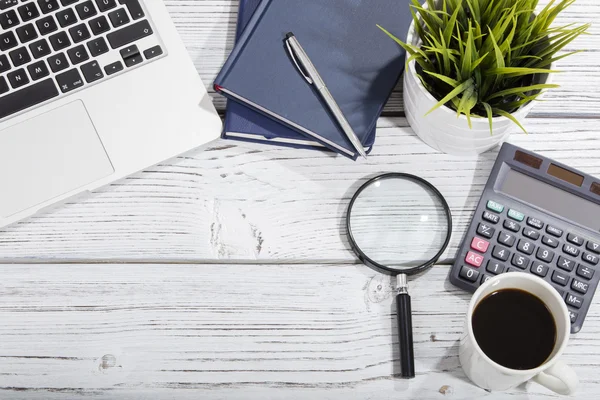 Mischung aus Bürobedarf und Gadgets auf einem Holztischhintergrund. Blick von oben — Stockfoto