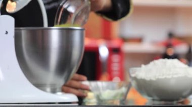 Şef malzemeleri kasede elektrikli mikserle karıştırıyor. Kek hamuru ağır çekimde hazırlanıyor