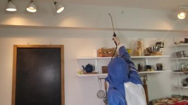 Koruyucu giysi dezenfekte mutfağında bir adam. Coronavirus haşere kontrolü