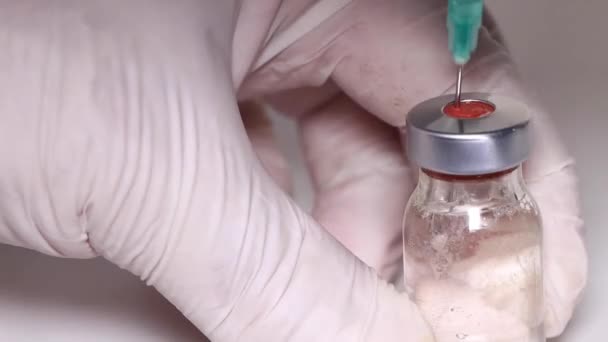 Die Nadel der Spritze nimmt Medizin aus der Glasflasche