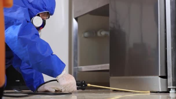 A man in a protective suit disinfection kitchen. Coronavirus pest control — Stock Video