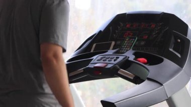 Kardiyo çalışması. Spor salonunda koşu bandında egzersiz yapan aktif bir adam.