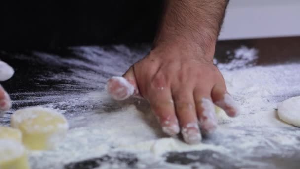 Um chef experiente em uma cozinha profissional prepara a massa, com farinha. — Vídeo de Stock