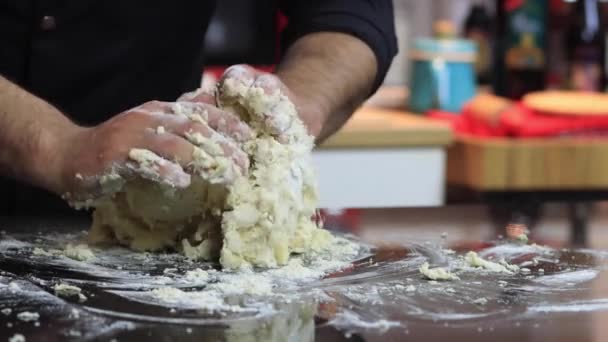 Um chef experiente em uma cozinha profissional prepara a massa, com farinha. — Vídeo de Stock