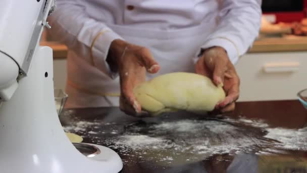 Um chef experiente em uma cozinha profissional prepara a massa, com farinha. — Vídeo de Stock