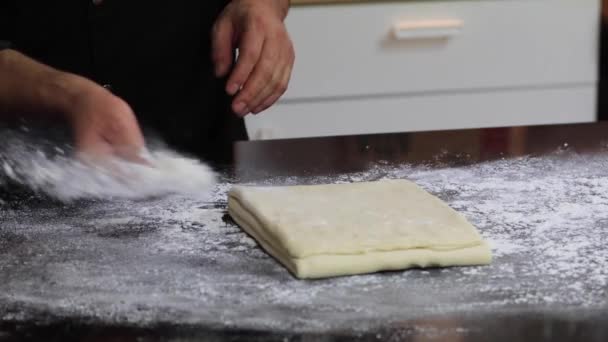 En erfaren kock i ett professionellt kök tillagar degen, med mjöl. — Stockvideo