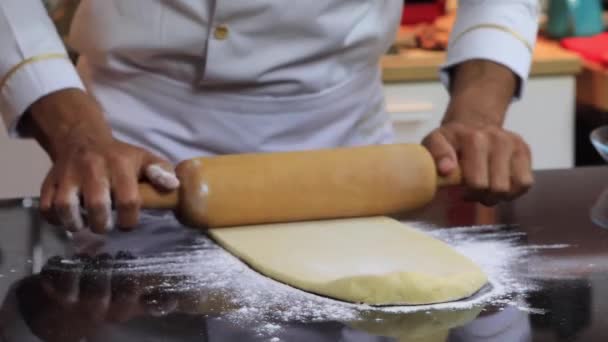 Um chef experiente em uma cozinha profissional prepara a massa, com farinha. — Vídeo de Stock