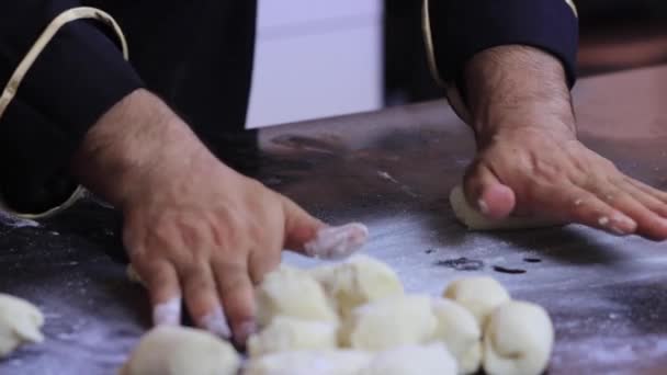 Um chef experiente em uma cozinha profissional prepara a massa, com farinha. — Vídeo de Stock