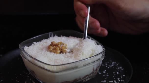 Desserts savoureux avec garniture, flocons de noix de coco. Quelqu'un coupe une pâtisserie avec une cuillère. — Video