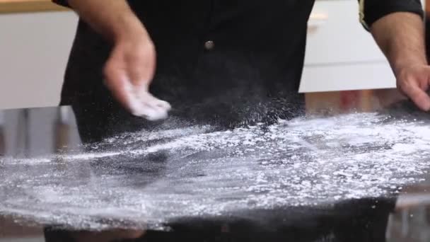 Um chef experiente em uma cozinha profissional prepara a massa, com farinha. — Vídeo de Stock