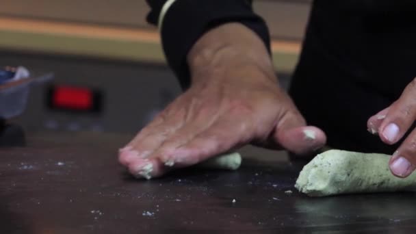 Um chef experiente em uma cozinha profissional prepara a massa, com farinha. — Vídeo de Stock