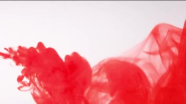 Suya kırmızı boya damlıyor, suya kırmızı mürekkep damlası düşüyor. Renkli mürekkep, 4K görüntü.,