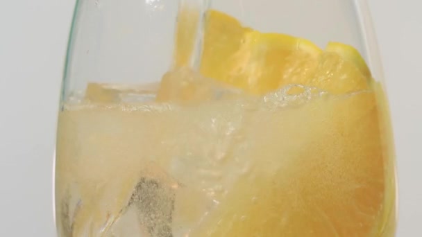 Makro-Nahaufnahme von kaltem, erfrischendem Soda Tonic sprudelndem Wassergetränk mit Blasen, die mit Eis und Kalk interagieren — Stockvideo