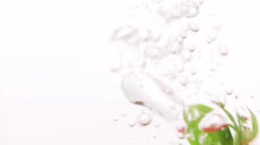 Beyaz arka planda köpüklerle suya düşen çilek. Suda taze meyveler. Organik böğürtlen, meyve, sağlıklı yemek. Yavaş çekim.