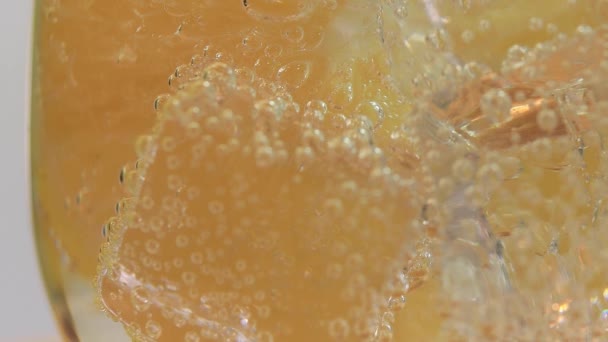 Macro primer plano de refresco frío refresco tónico agua gaseosa bebida con burbujas interactuando con hielo y cal — Vídeo de stock