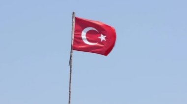 Türkiye 'nin yakın çekim bayrağı mavi bir arka planda rüzgarda dalgalanıyor