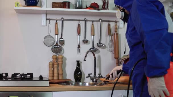 Ένας άνθρωπος σε μια προστατευτική στολή απολύμανση κουζίνα. Έλεγχος παρασίτων του Coronavirus — Αρχείο Βίντεο