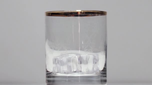 Whiskey öntése az üvegbe jéggel — Stock videók