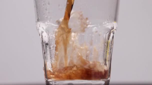 Коли кола - сода виливається у склянку льоду з брисками. — стокове відео