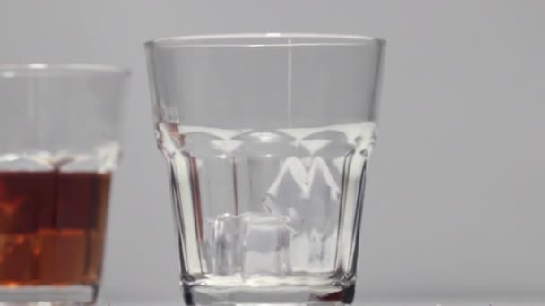 Wlewanie whisky do szklanki z lodem — Wideo stockowe