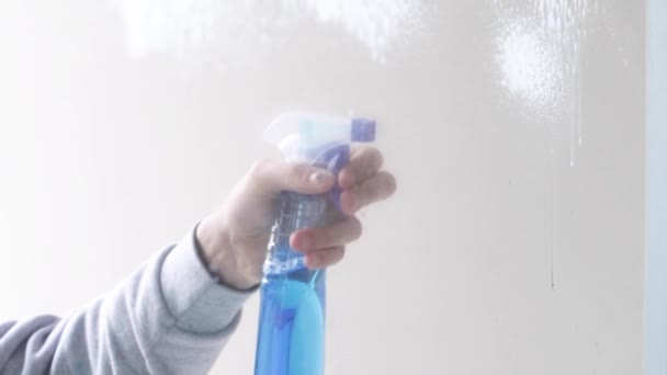 Закріпіть руки блакитними рукавицями, чистячи вікно, використовуючи забруднену воду — стокове відео