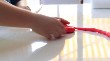 Childs 'ın elleri masada renkli kil oynuyor. Parmaklarının ve yaratıcılığının ve eğitiminin iyi motor becerilerinin geliştirilmesi