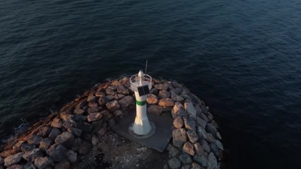 Panorama tir de drone d'un phare à l'heure d'or avec l'océan et le soleil — Video