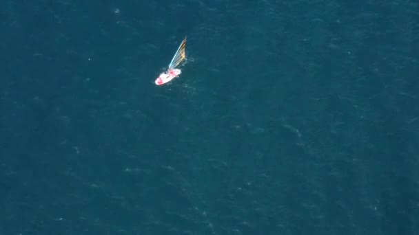 Flygdrönare syn på en man på vindsurfing i Egeiska havet. Genomskinligt vatten. — Stockvideo