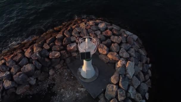 Panorama drone shot of a lighthouse at golden hour with ocean and sun — Stock Video