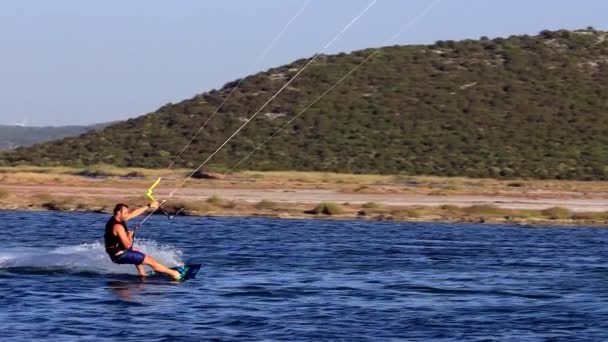 Gulbahce, - Izmir srpen 03 - 2021: Kitesurfer surfování v gulbahce kitesurfing point s drakem. — Stock video