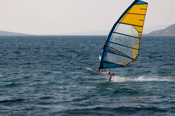 Windsurfing, extreme sports. Water sports. Athlete in competition. Seascape with athlete.