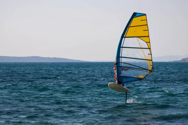 Windsurfing, extreme sports. Water sports. Athlete in competition. Seascape with athlete.