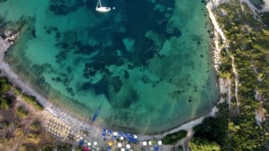 Yukarıdan bakıldığında, şeffaf ve turkuaz bir denizde yüzen bir teknenin havadan görünüşü. Urla, izmir, Türkiye.