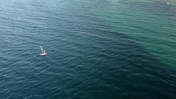 Flygdrönare syn på en man på vindsurfing i Egeiska havet. Genomskinligt vatten. — Stockvideo