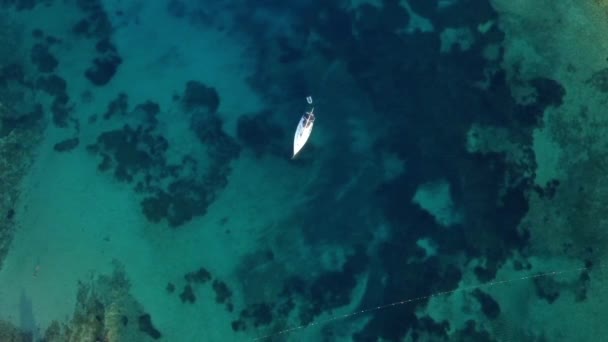 Blick von oben, Luftaufnahme eines Bootes, das auf einem transparenten und türkisfarbenen Meer segelt. Urla, izmir, Türkei. — Stockvideo
