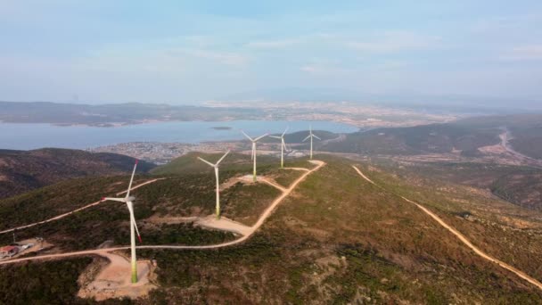 Drone Flies Over een Windmolen Park. Luchtfoto van een boerderij met windturbines. Windenergie Turbines die schone hernieuwbare energie opwekken voor duurzame ontwikkeling. — Stockvideo