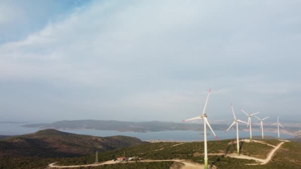 Drönare flyger över en väderkvarnspark. Flygfoto över en gård med vindkraftverk. Vindkraftverk som genererar ren förnybar energi för hållbar utveckling. — Stockvideo