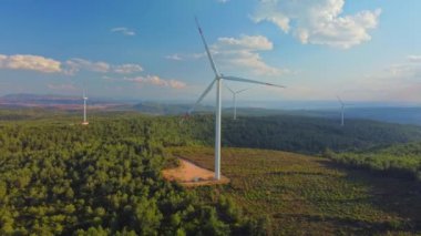Drone bir yel değirmeni parkının üzerinde uçuyor. Rüzgar türbinli bir çiftliğin hava görüntüsü. Rüzgâr Güç Türbinleri Sürdürülebilir Gelişme İçin Temiz Yenilenebilir Enerji Üretiyor.
