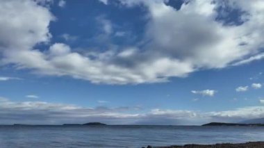 Hareketli Bulutlar ve Yansıyan Gökyüzü ile Sakin Deniz Zamanı. Yüksek kalite 4k görüntü