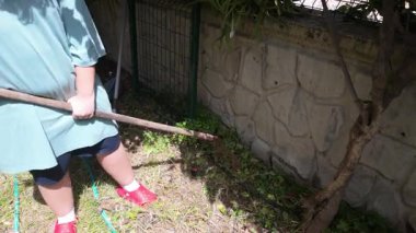 Bahçedeki Çocuk İnatçı Kökü Taştan Duvarın yanında Turkuaz Hortumlu, Kırmızı Spor Ayakkabılı