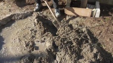 DIY İnşaat: Düz Yüzey İçin Bahçede Kürek ile İşçi Karıştırma Betonu. Yüksek kalite 4k görüntü