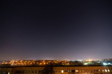 Bir sürü yıldız ve takımyıldızlı gece yıldızlı şehir manzarası. Yüksek binanın çatısından görüntüle.