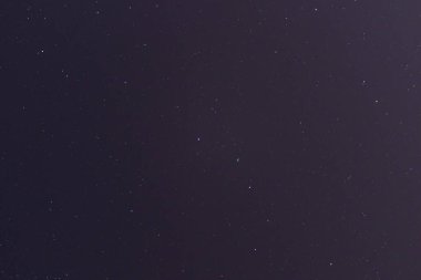 Şehirde bir sürü yıldız ve takımyıldızı olan gece yıldızlı gökyüzü. Şehir ışıkları derin gökyüzünde.