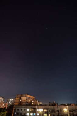 Bir sürü yıldız ve takımyıldızlı gece yıldızlı şehir manzarası. Yüksek binanın çatısından görüntüle.