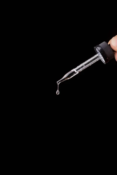 Siyah arkaplanda izole edilmiş saydam sıvı damlası