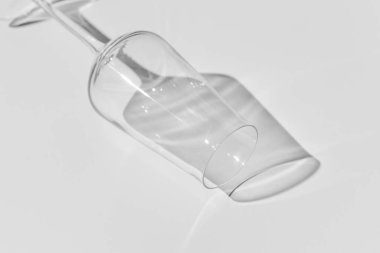 Beyaz yüzeyde şampanya kadehi. Beyaz masadaki gölgeli cam..