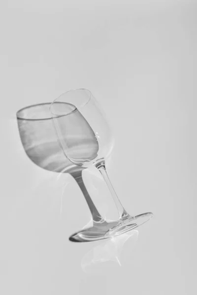 Wine glass lies on white background. Glass with hard shadow in monochrome — Stockfoto