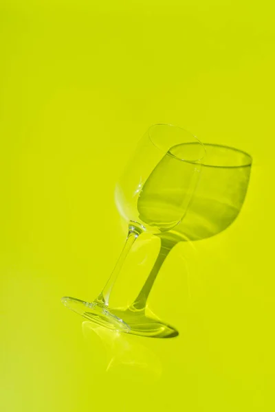Wine glass lies on lemon green background. — Stock Photo, Image
