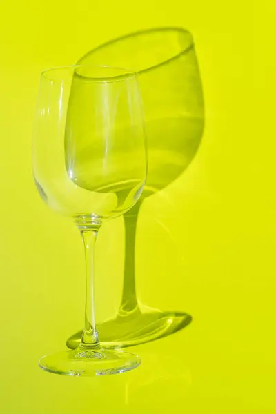 Wine glass lies on lemon green background. — Stock Photo, Image