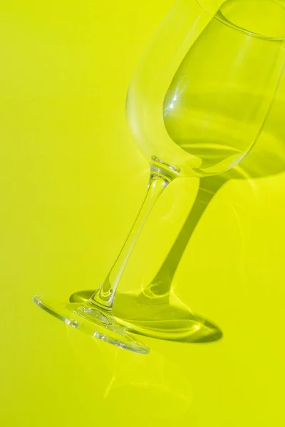 Wine glass lies on lemon green background. — Stock Photo, Image